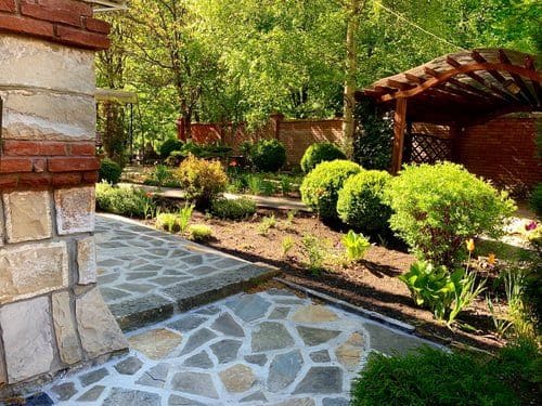 Landscaped Virginia backyard bordered by a wood fence and mature planting